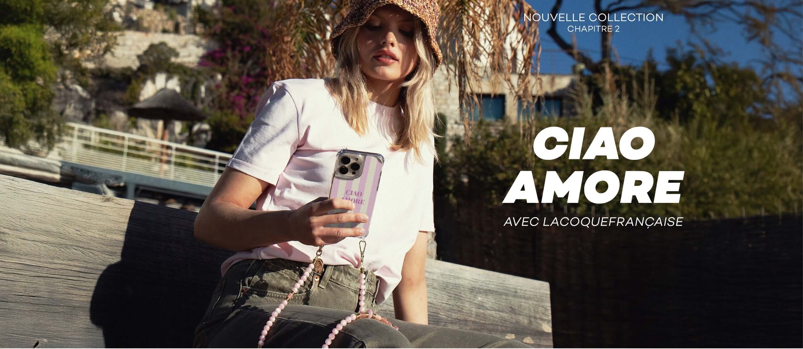 Stylish young woman wearing  La Coque Francaise CF phone chain by La Coque Francaise, available in Switzerland at 99things.ch – chic phone accessory La Coque Francaise Phone Chain with her mobile phone to travel hands- free