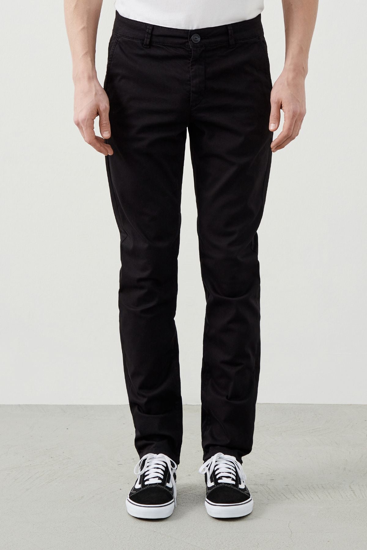 Stylish black chinos combined with black sneakers, perfect for casual or formal wear.