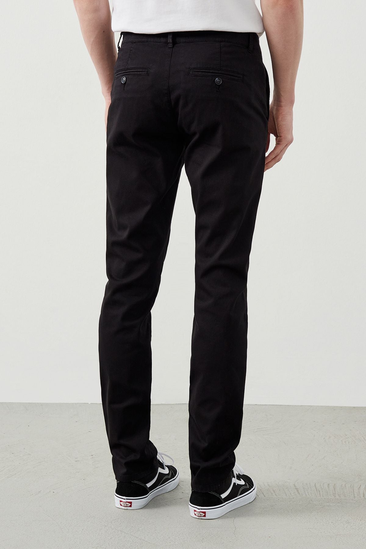 Back view of sleek black chino pants, featuring buttoned back pockets for added style and functionality.