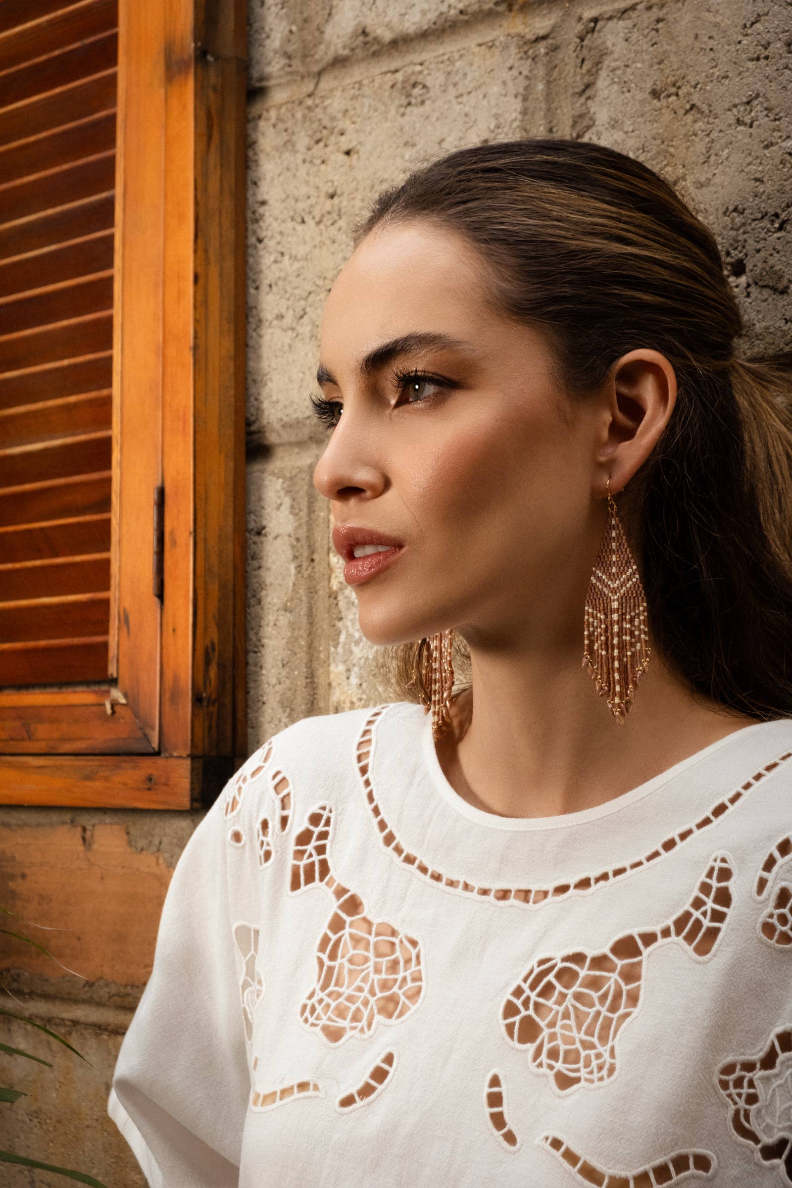 Woman wearing Mayana Designs Taos Fringe Earrings in Light Brown, showcasing their elegant geometric design and fringe details