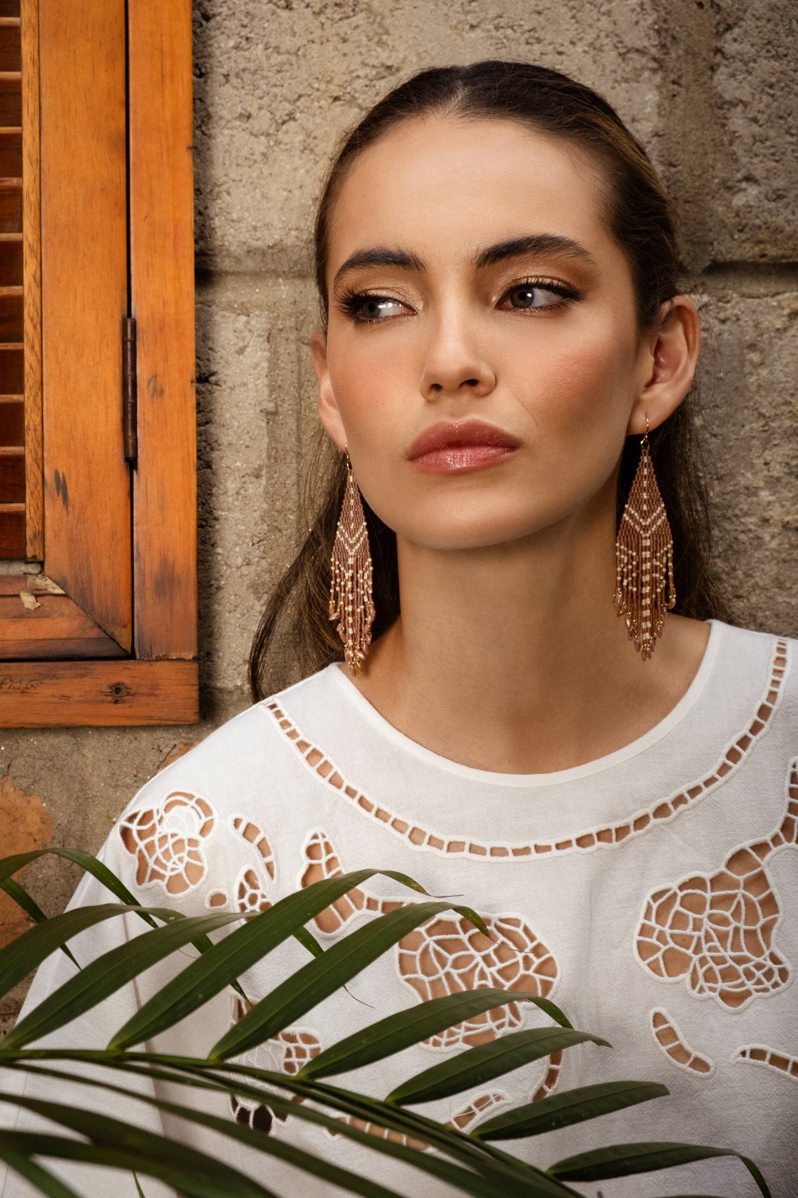 Woman wearing Mayana Designs Beaded Handwoven Taos Fringe Earrings in Light Brown.