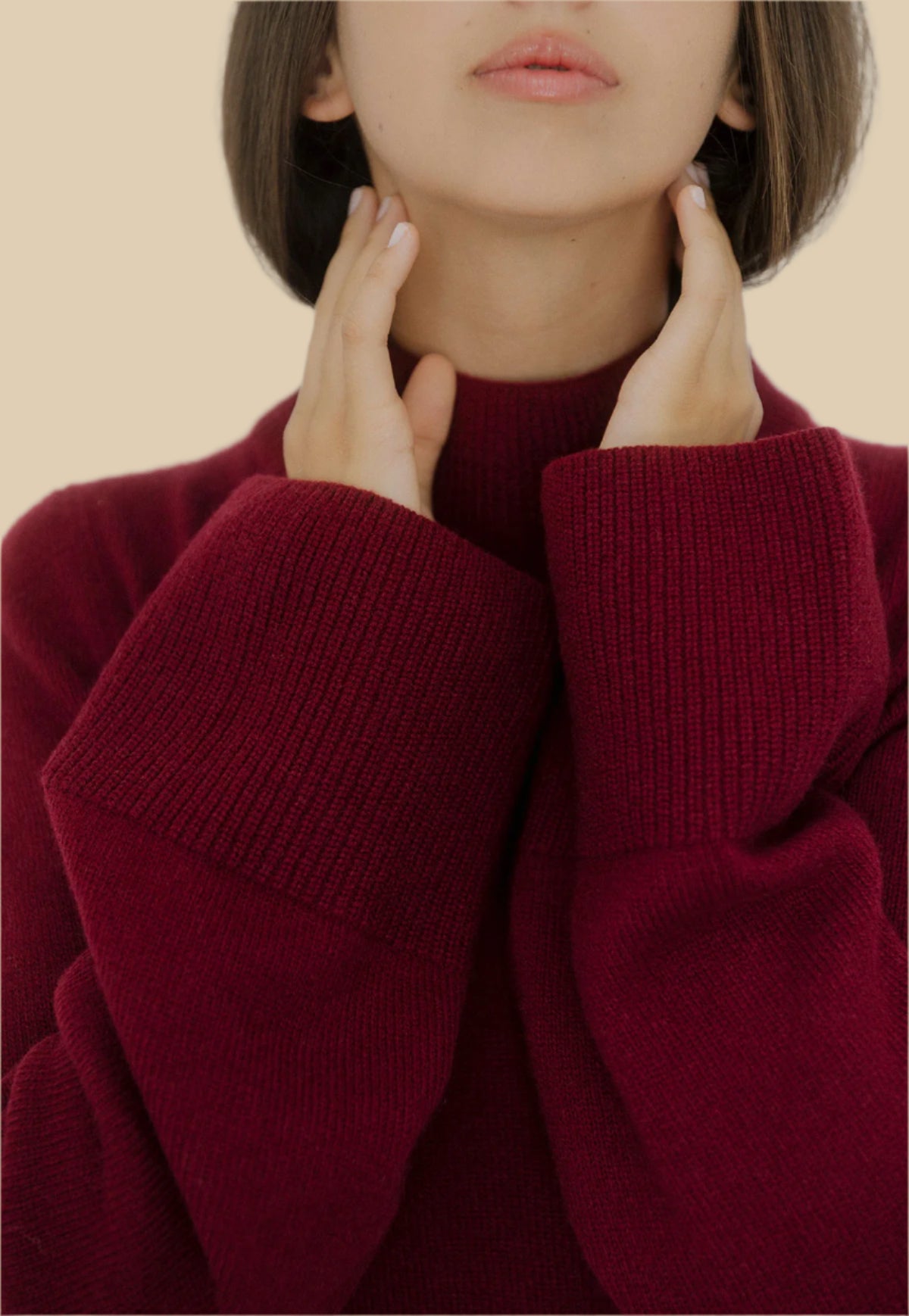 Front view of a women’s burgundy wide-sleeve cashmere sweater by Nuage Cashmere with high neck and wide sleeves, displaying its elegant, minimalistic design in a deep wine color