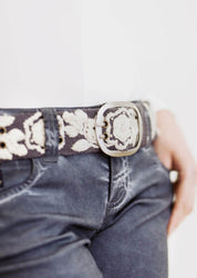 Woman wearing the Smitten Two-Tone Stone Handwoven Belt over a dress, showcasing its elegant handcrafted details