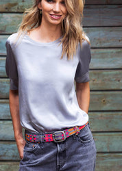 Woman wearing the Adriana Peppy Handwoven Belt by Smitten in grey and pink, styled with a casual dress for a chic, colorful look