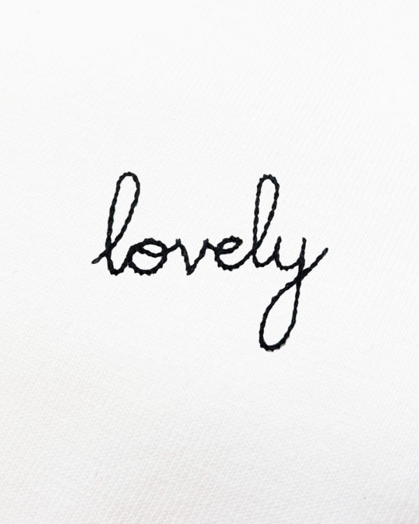 Detailed view of elegant black hand embroidery spelling 'lovely'