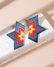 Handcrafted half-star earrings in red and emerald beads, showcasing the beautiful mix of colors and details in a bold design.