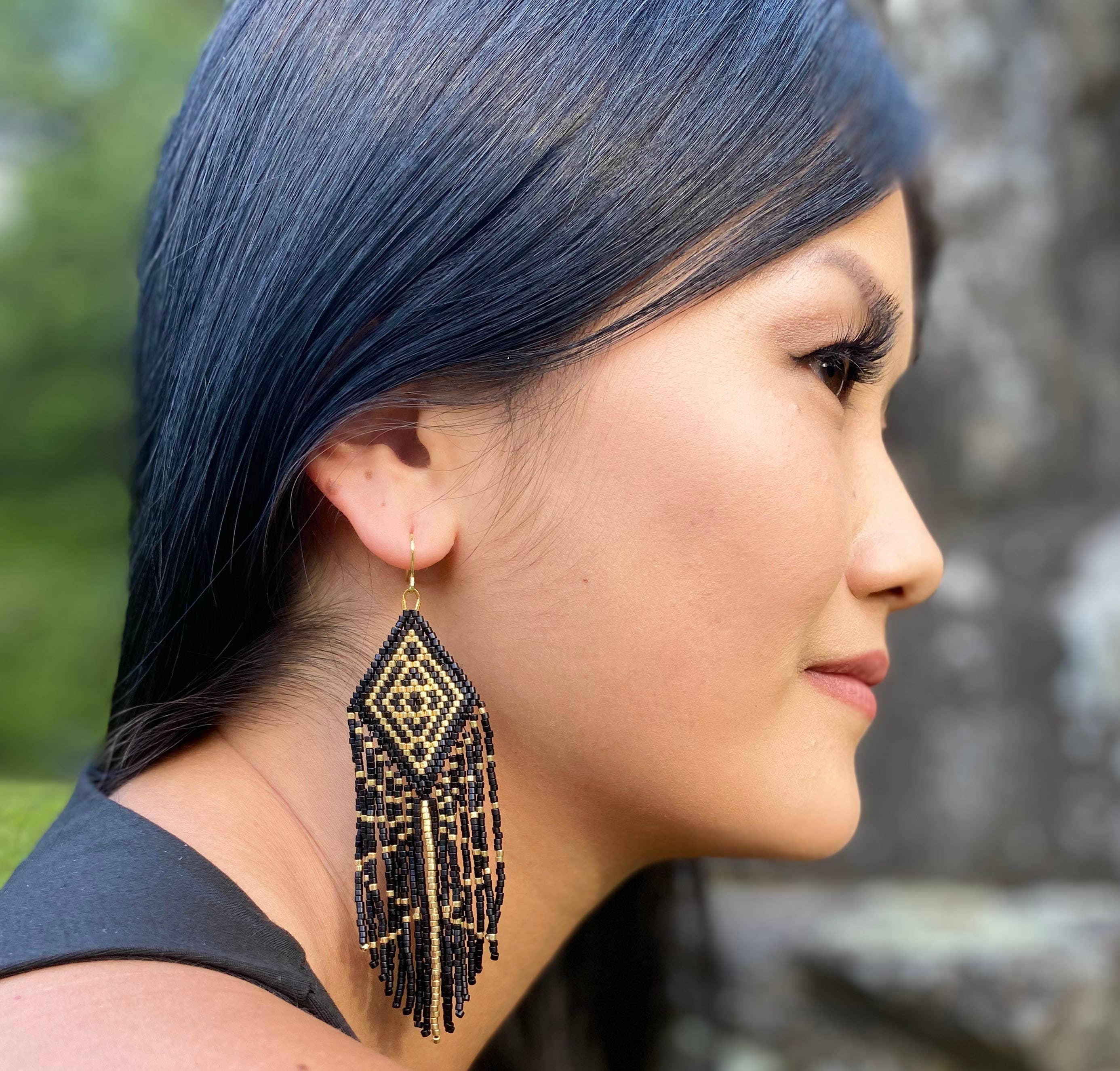 Woman wearing Beaded Tribal Diamond Fringe Earrings at Music Festival -  Profile view with gold accents.