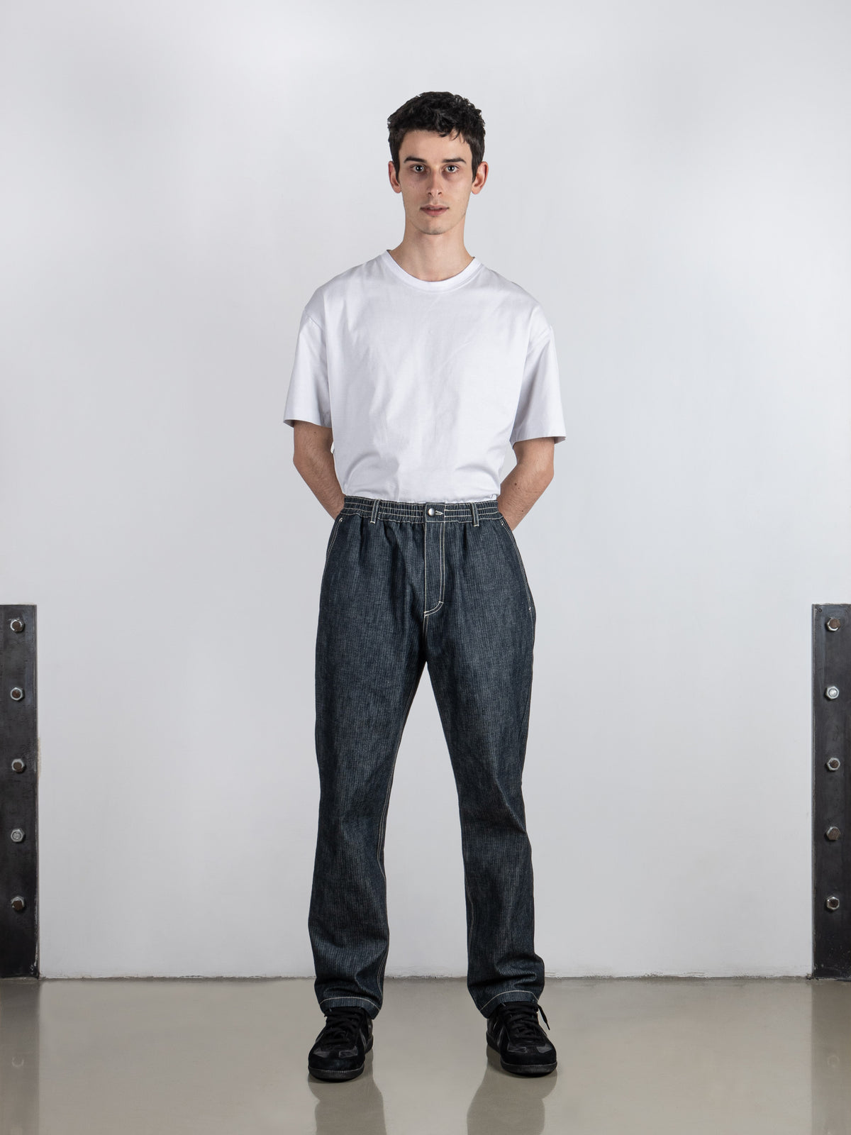 Young man wearing the jeans combined with a white tee, exuding style and confidence.