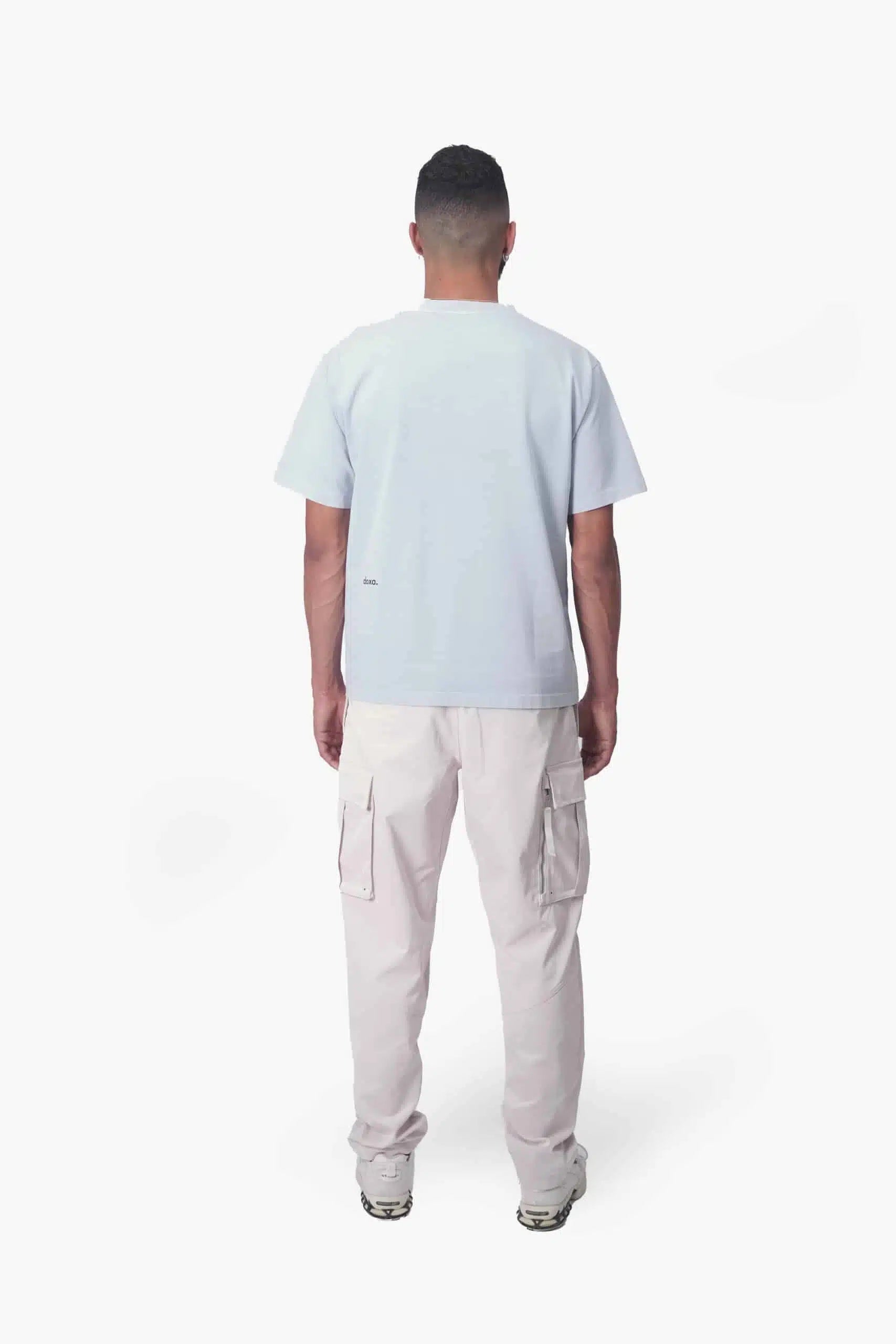 Man wearing a sustainable style light blue tee by DOXA, crafted with natural mineral dye.