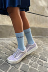 a person wearing a pair of blue Chaton Gonflable Open Intarsia Organic Cotton Socks.