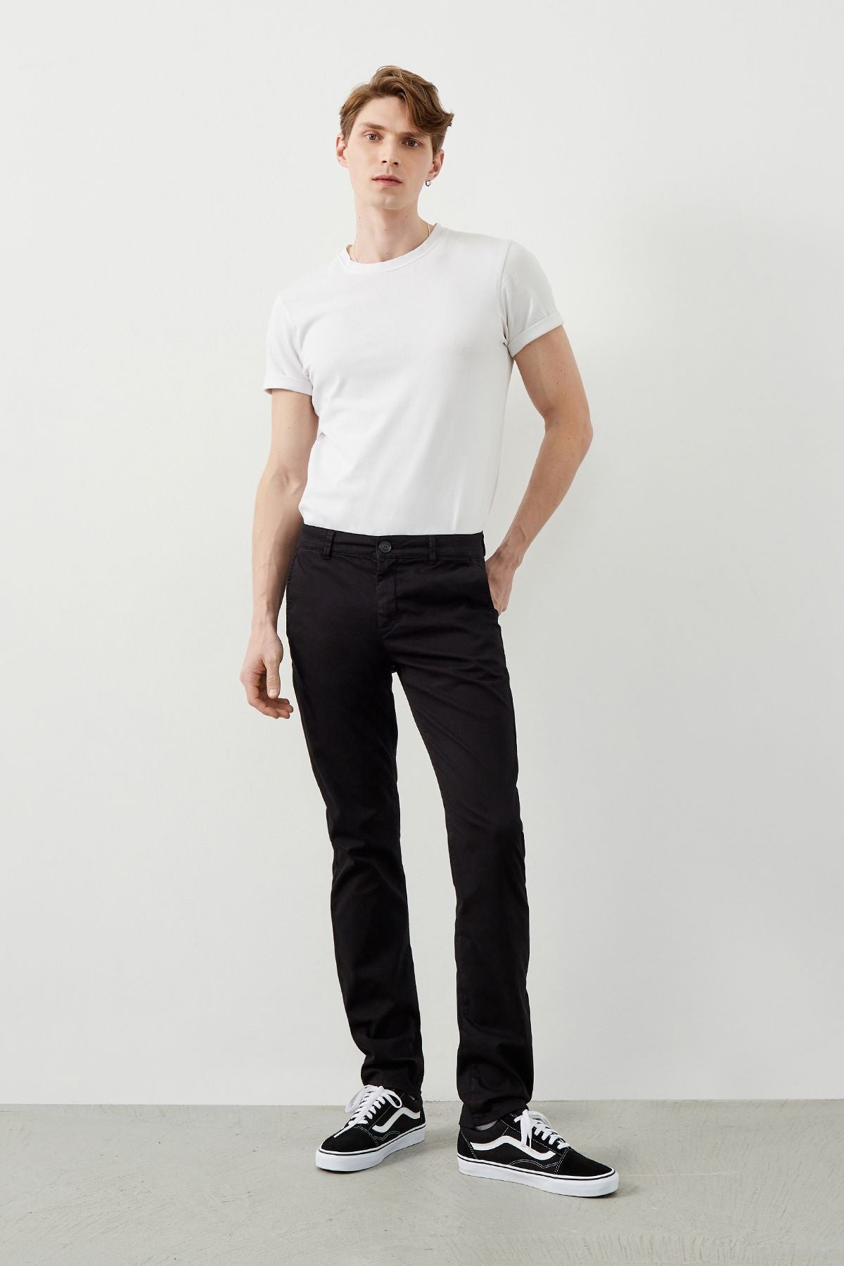 Man wearing sleek black chinos and white classic cotton t-shit from Ra Denim Collection, showcasing modern style.