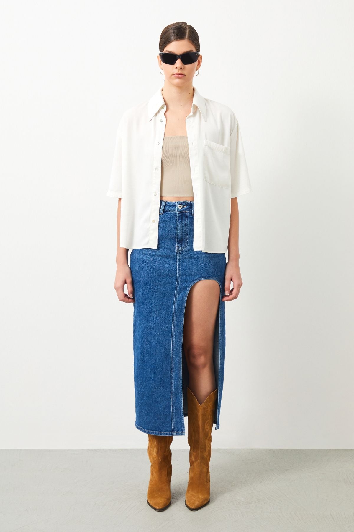 Stylish outfit combining ecru white blouse and blue denim skirt.