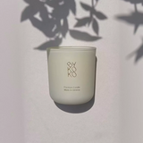 BYKOKO Cosy Cottage scented candle in frosted glass with soft leaf shadows