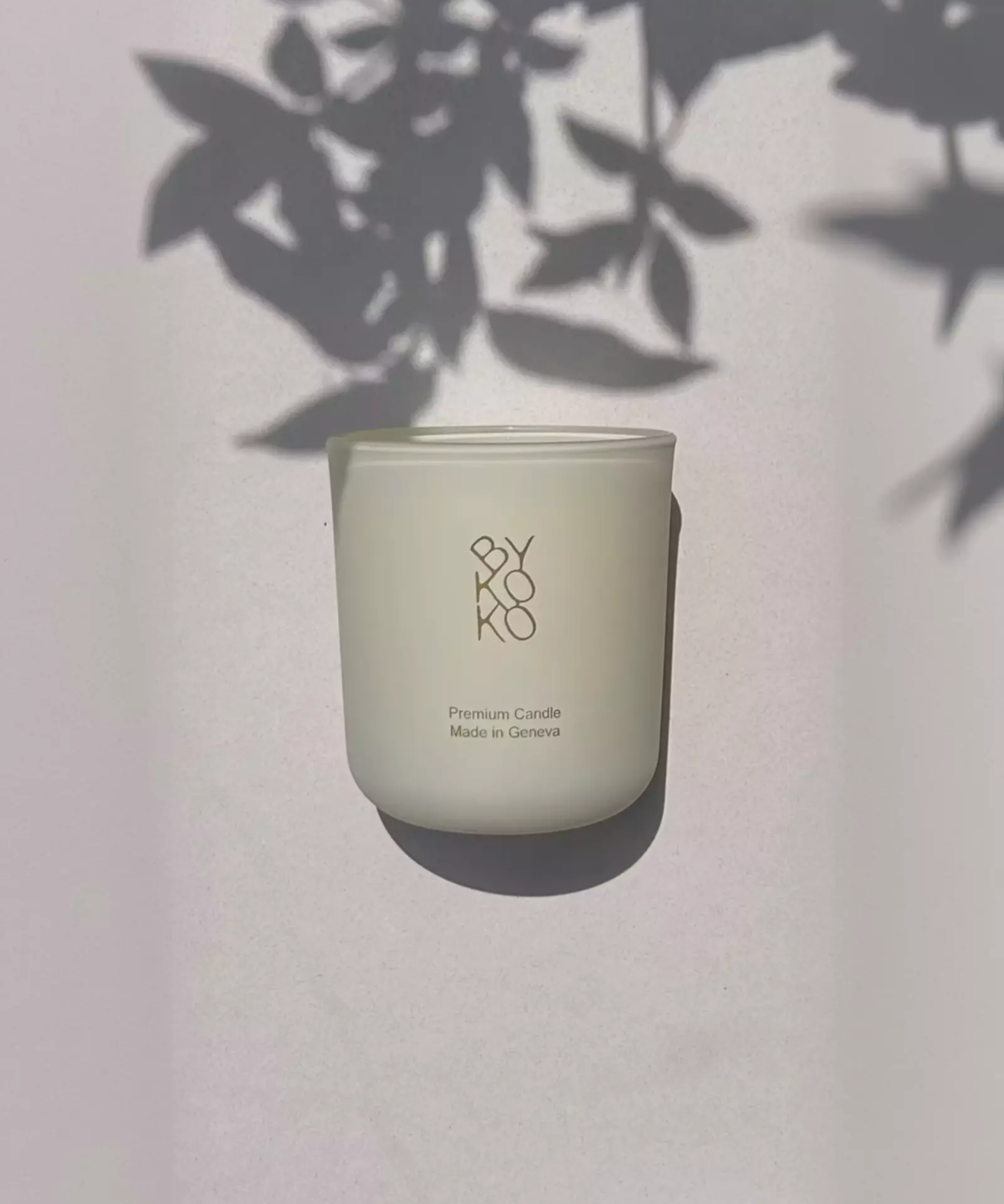 BYKOKO Cosy Cottage scented candle in frosted glass with soft leaf shadows