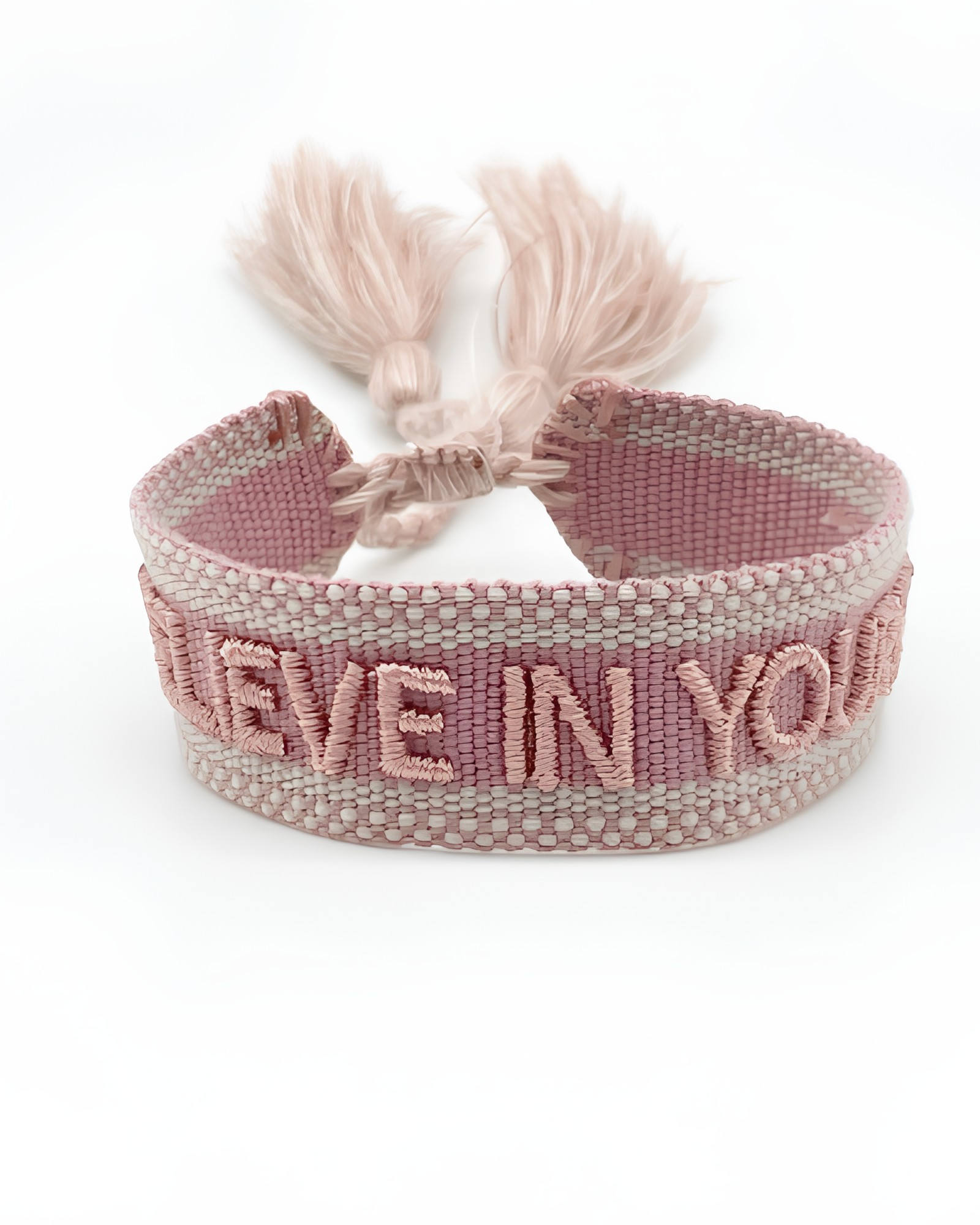 Close-up of adjustable vintage rose woven friendship bracelet featuring embroidered "BELIEVE IN YOURSELF" lettering and sliding knot tassel cords.