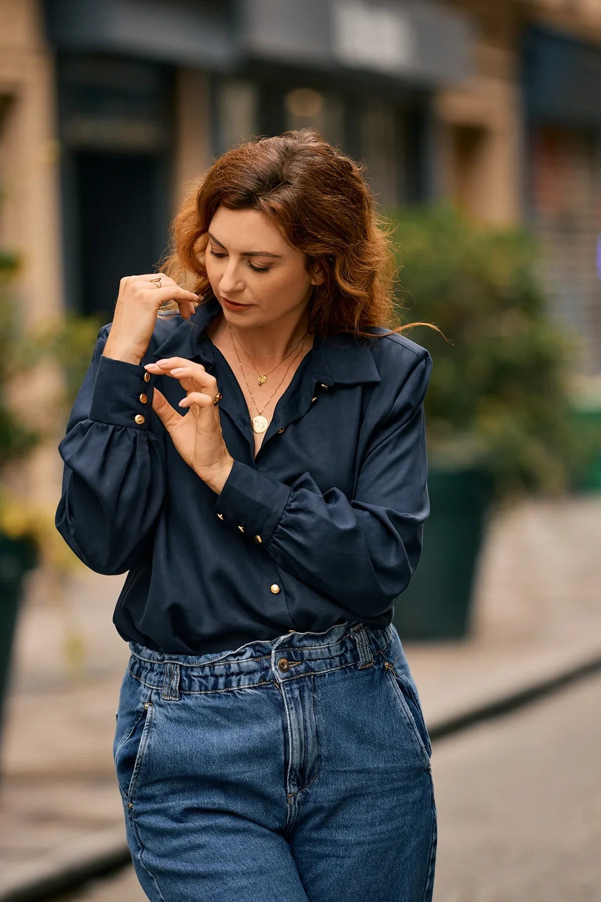 Woman in the city wearing a dark blue Tencel blouse by KS Vestiaire Intemporel with a blue jeans