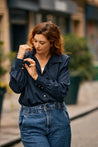 Woman in the city wearing a dark blue Tencel blouse by KS Vestiaire Intemporel with a blue jeans