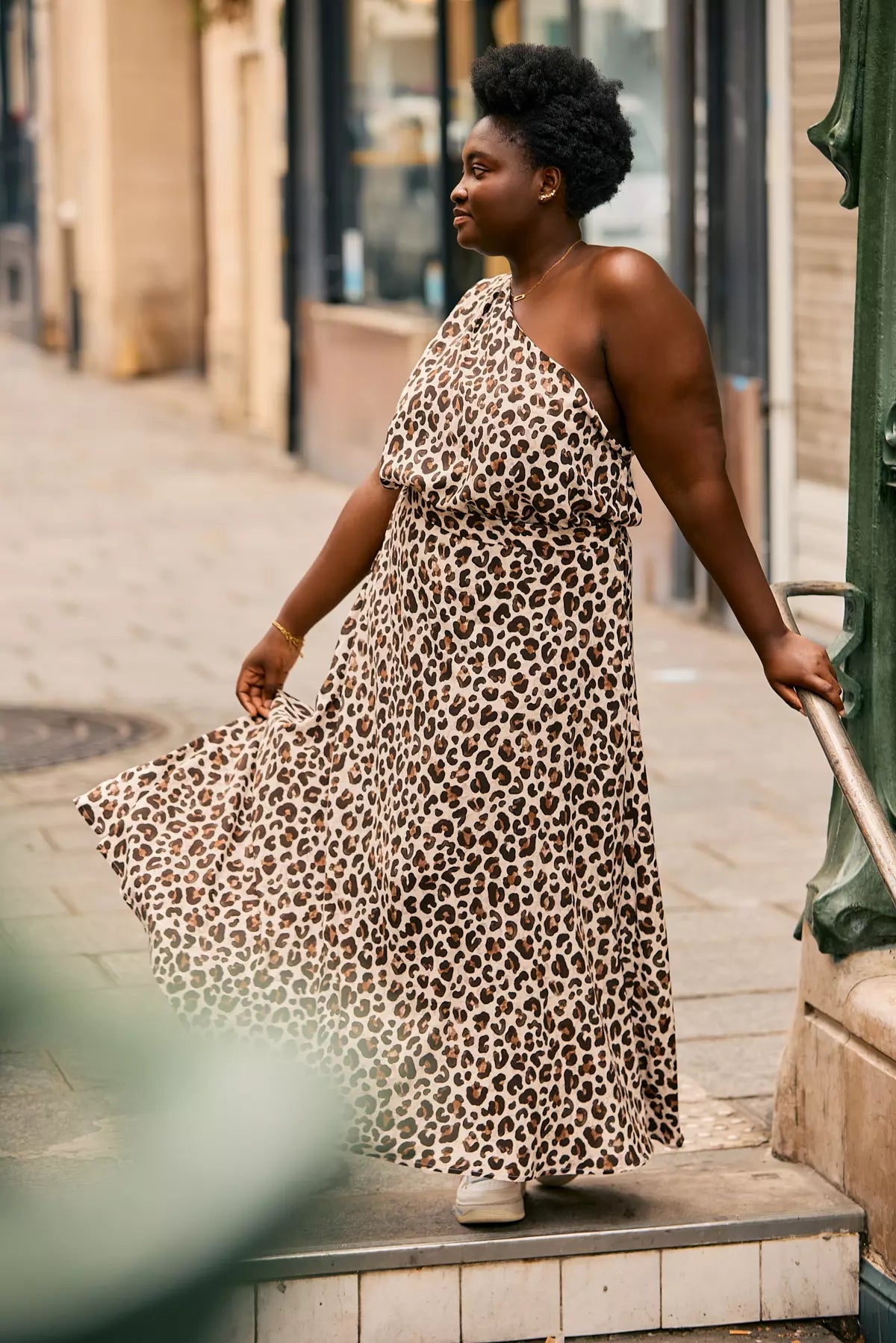 Woman wearing long BILLIE Leopard skirt paired with a one-shoulder top for a chic look.