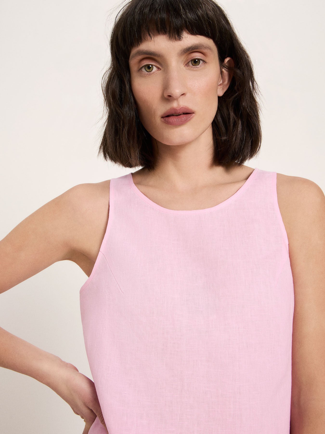 Woman wearing a pink sleeveless linen top by fair fashion brans Lanius.