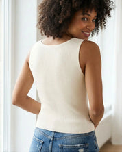 Back view of a woman wearing an off-white organic cotton rib knit tank top with a sleeveless, slim fit.