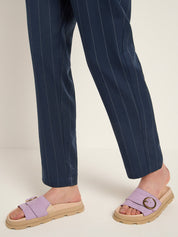 Person wearing navy pinstripe pants and purple sandals 