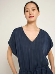 Woman wearing a navy pinstripe jumpsuit