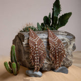 Mayana Designs Beaded Handwoven Taos Fringe Earrings in Light Brown on display. Highlighting the intricate beadwork and fringe design