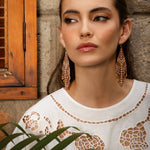 Woman wearing Mayana Designs Beaded Handwoven Taos Fringe Earrings in Light Brown.