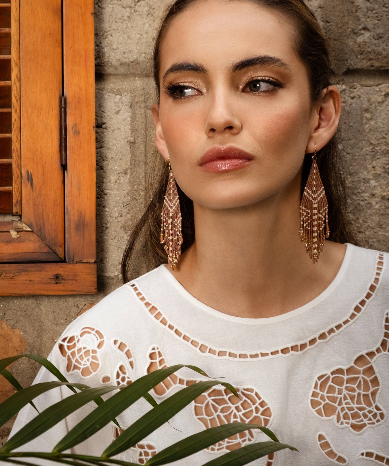 Woman wearing Mayana Designs Beaded Handwoven Taos Fringe Earrings in Light Brown.