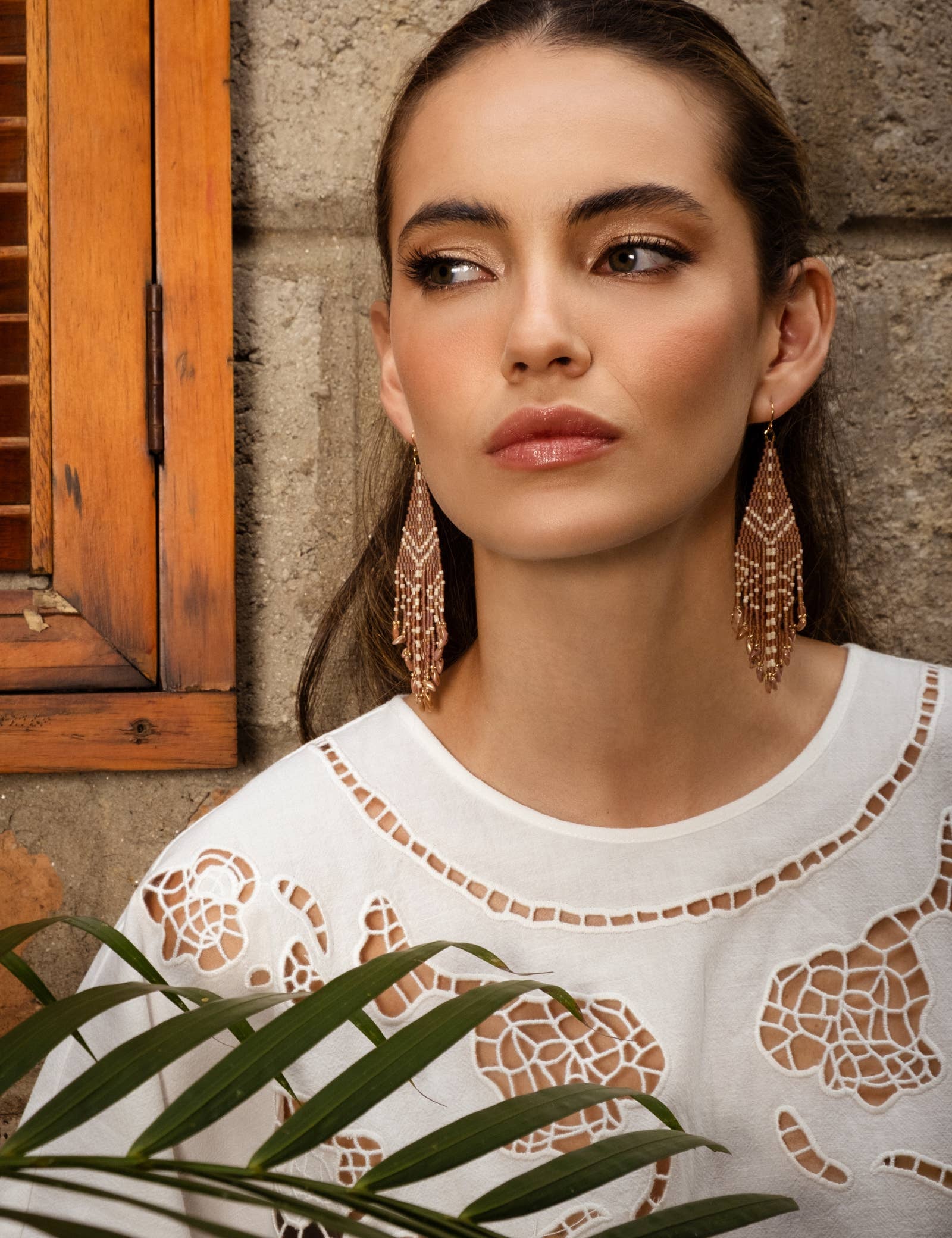 Woman wearing Mayana Designs Beaded Handwoven Taos Fringe Earrings in Light Brown.