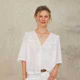 Model wearing Frill Detail Blouse in Ivory styled with white jeans.