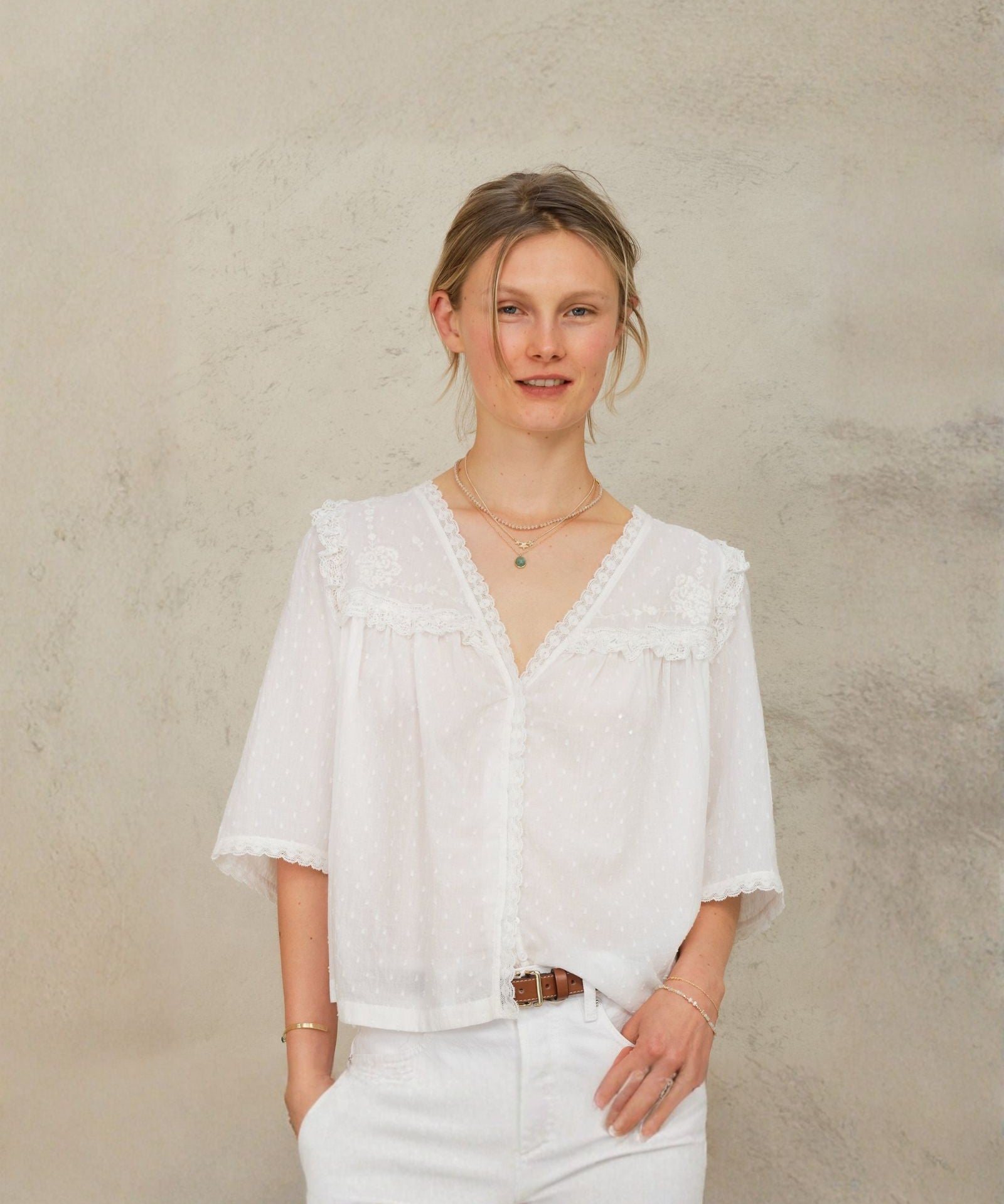 Model wearing Frill Detail Blouse in Ivory styled with white jeans.