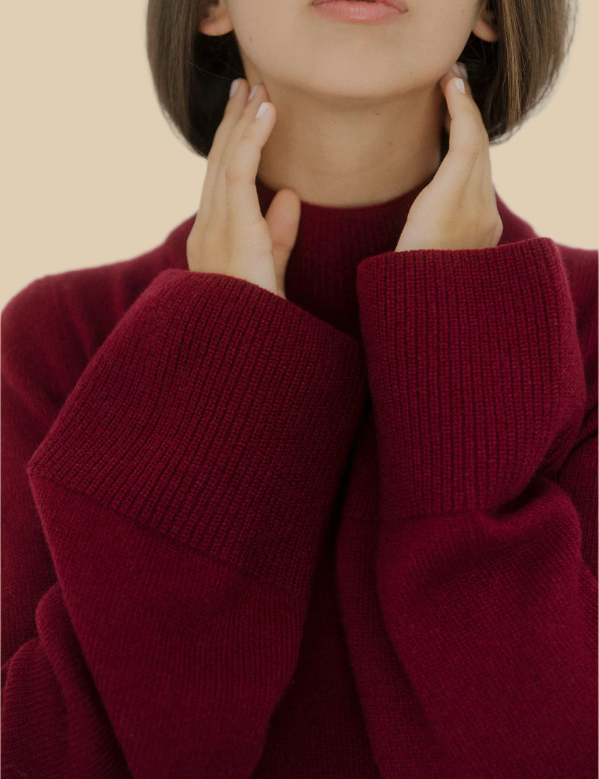 Front view of a women’s burgundy wide-sleeve cashmere sweater by Nuage Cashmere with high neck and wide sleeves, displaying its elegant, minimalistic design in a deep wine color