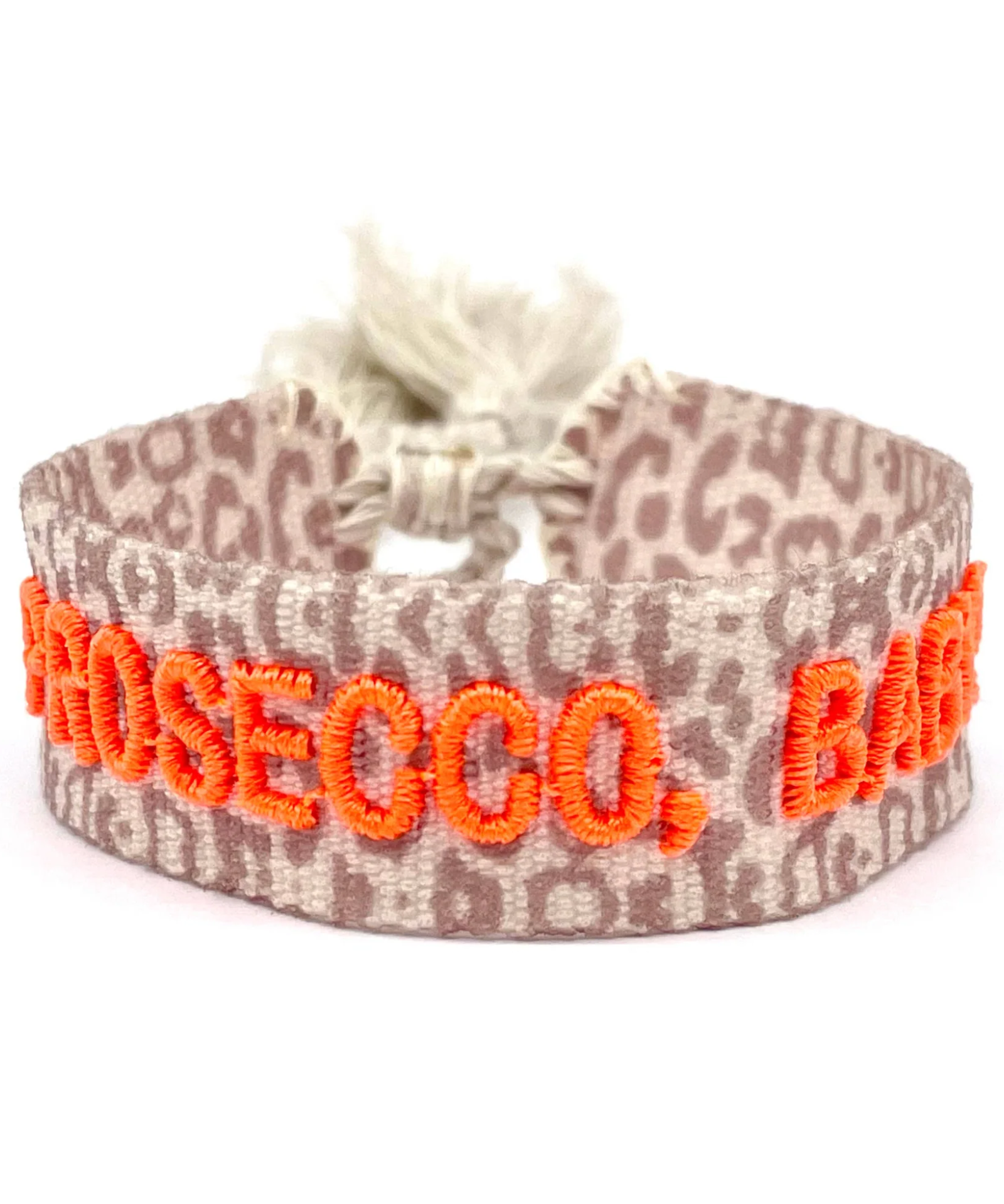 Close-up of adjustable woven friendship bracelet with Leo pattern and neon orange embroidered "PROSECCO, BABY!" lettering with sliding knot cords.