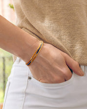Woman wears Miyuki Beaded Stretch Bracelet Trio in Peach Aqua Tan – a colorful, elegant bracelet set.