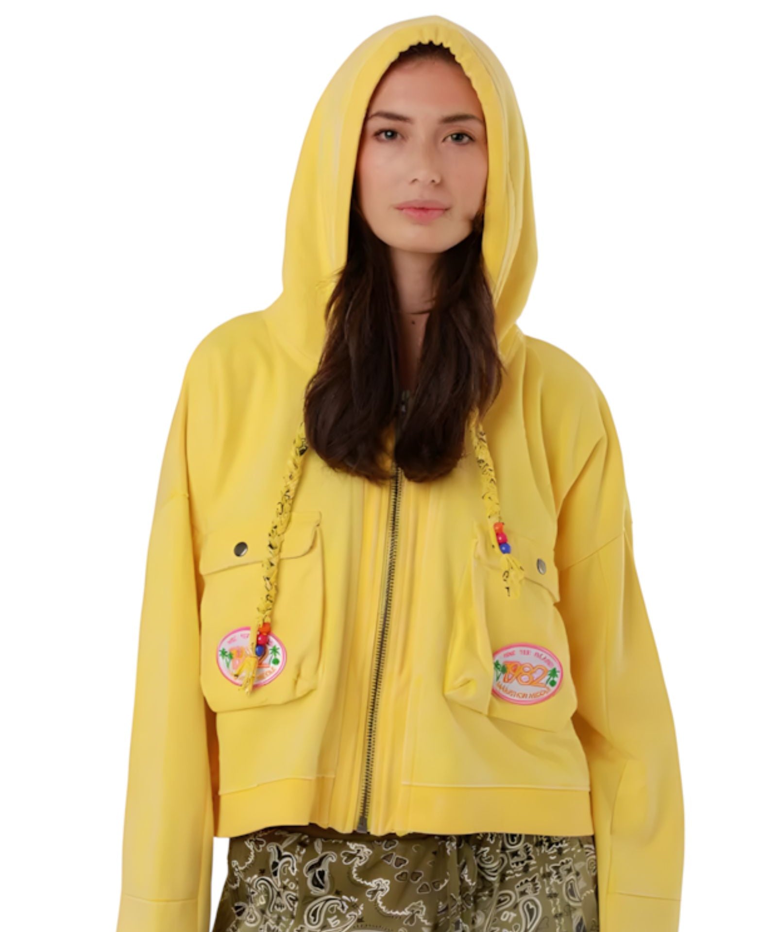 Front studio view of a model with the hood up on the washed yellow Amy cotton jacket, showcasing its straight silhouette.