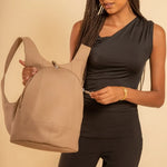 Model wearing the ARSAYO Mela backpack in beige AppleSkin