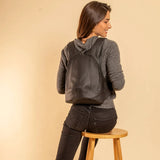 Model wearing the ARSAYO Mela backpack in black AppleSkin
