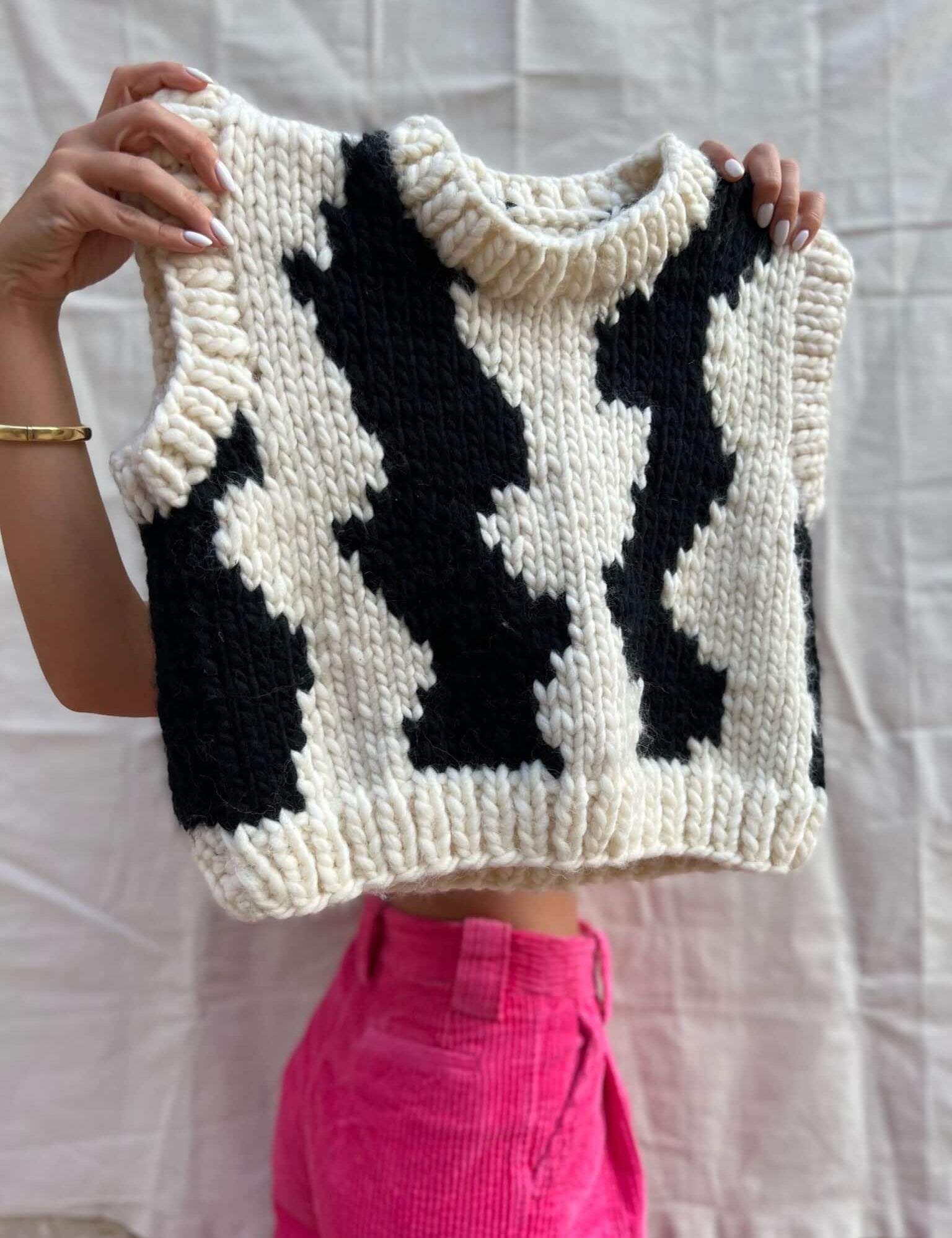 Detailed view of White wool vest by Atelier 8|02, featuring black wave design.