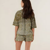 Rear view of the green bandana print shorts on a model, showcasing the comfortable casual fit and all-over vintage pattern.