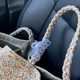 Bon Dep Love Hair Claw 8cm lavender clipped onto a floral-patterned handbag strap.