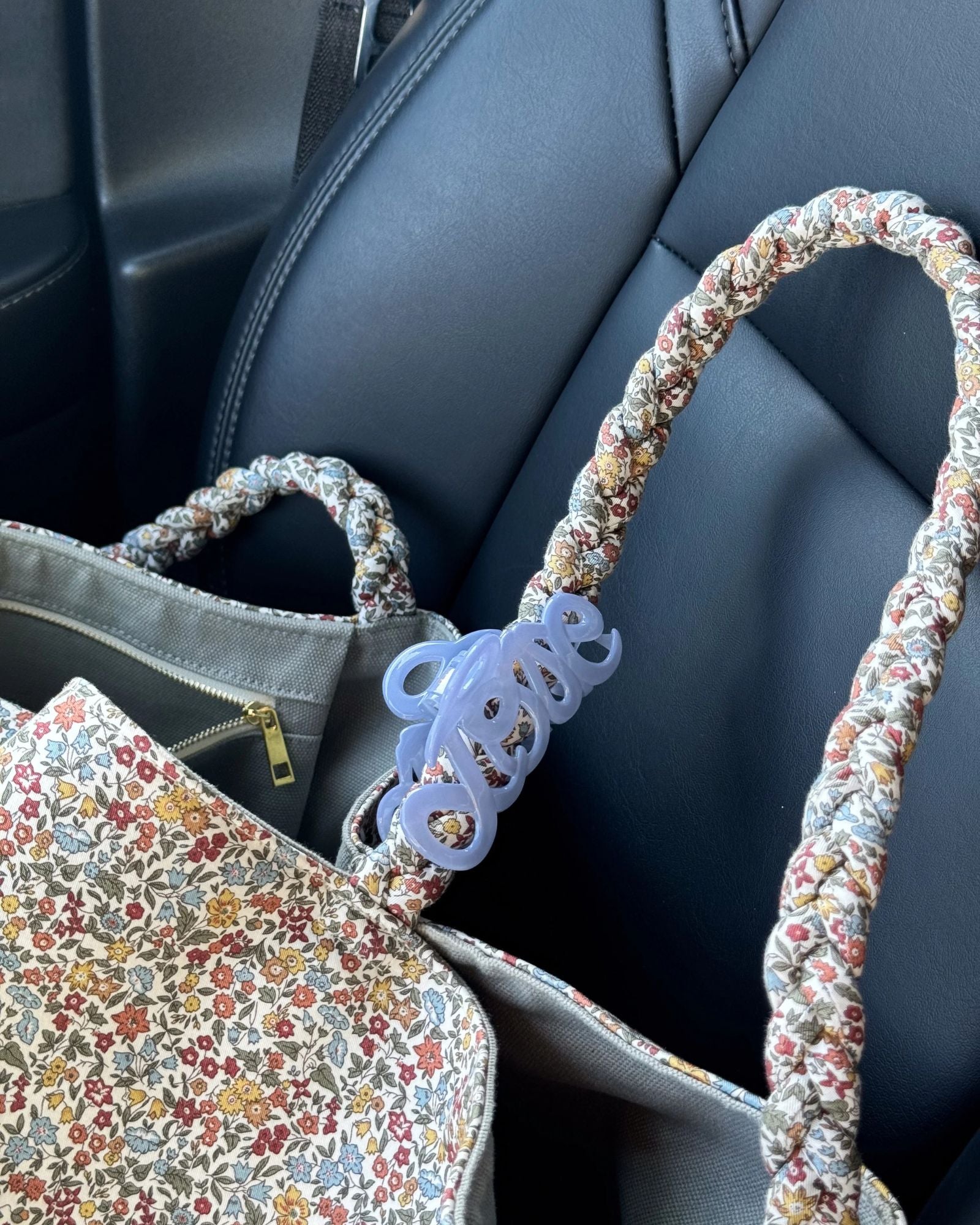 Bon Dep Love Hair Claw 8cm lavender clipped onto a floral-patterned handbag strap.