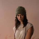COLORUSH Byron beanie in Kiwi, model seated with burgundy gloves