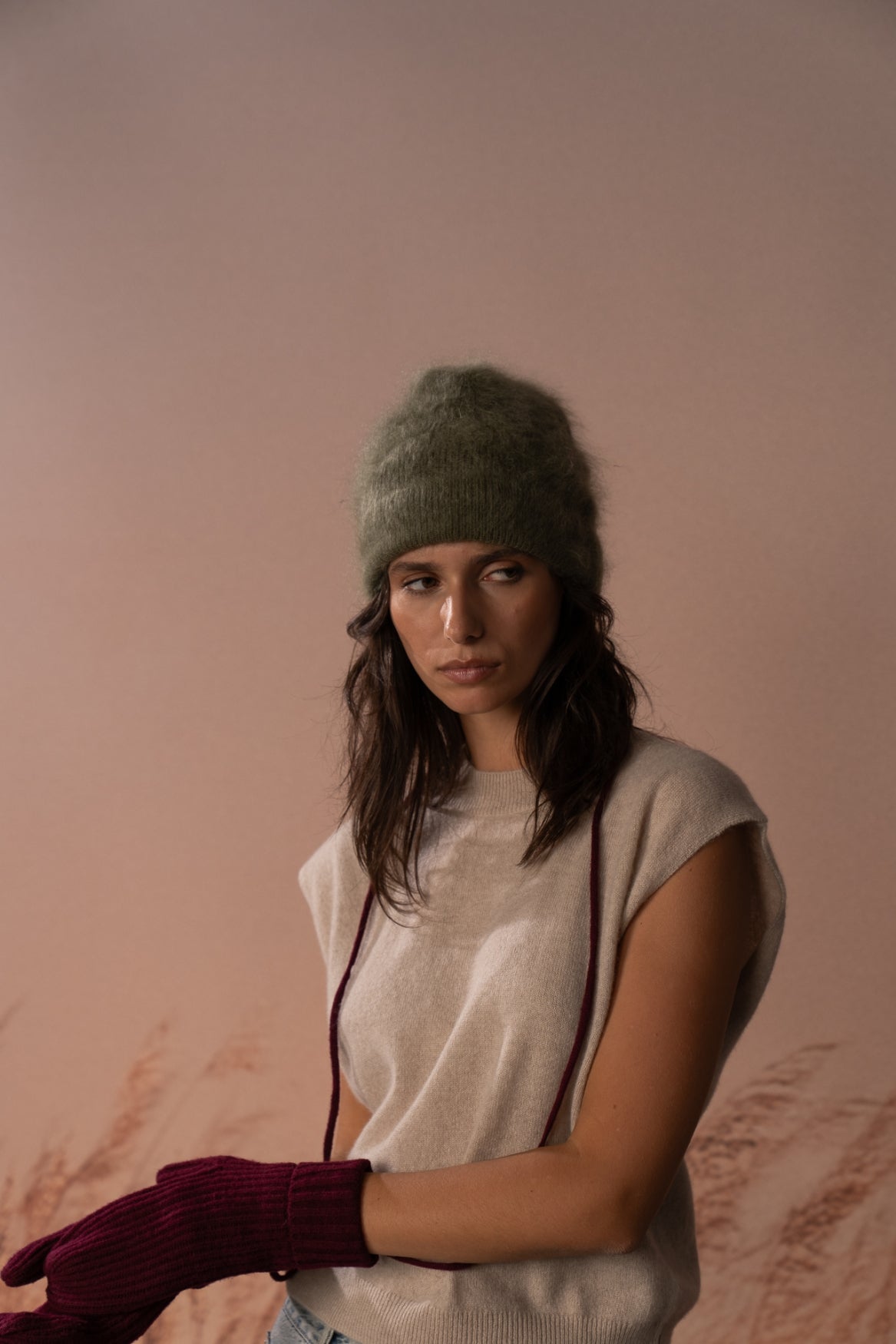 COLORUSH Byron beanie in Kiwi, model seated with burgundy gloves