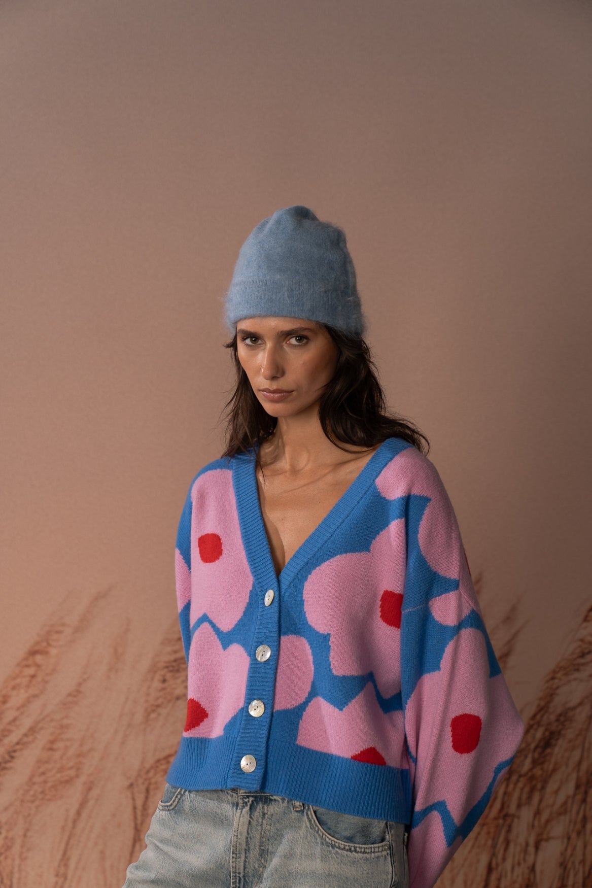 COLORUSH Byron cashmere beanie in Stonewash, worn from the front with a pink and blue cardigan