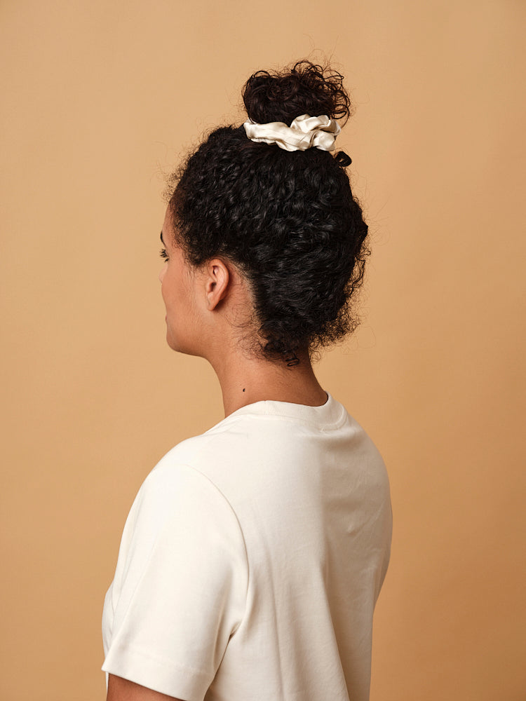 Emily's Pillow large pure silk scrunchie in champagne worn in a high bun