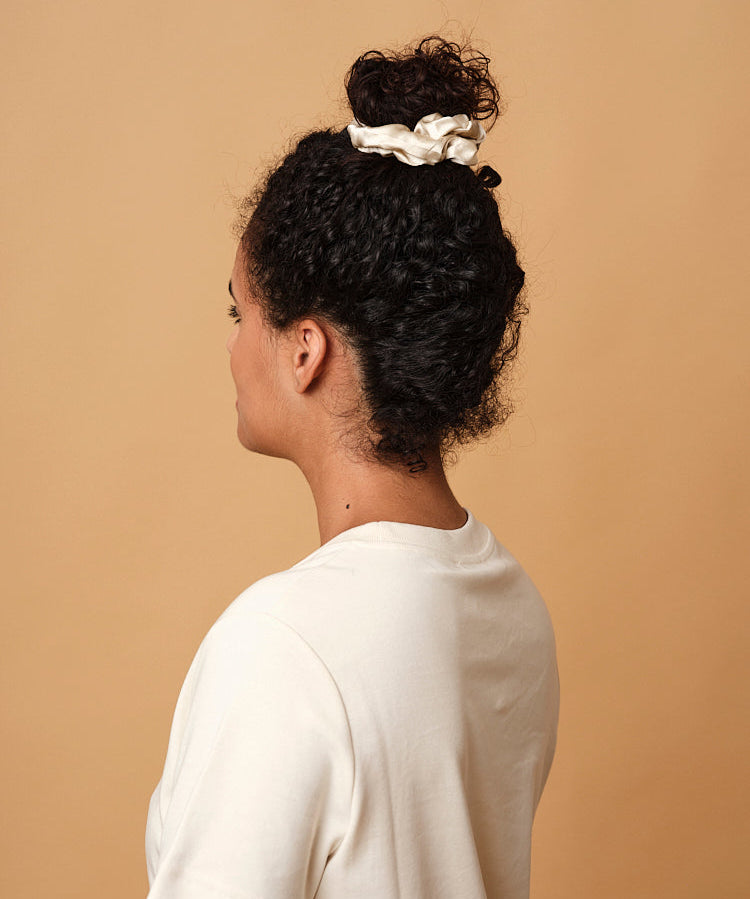 Emily's Pillow large pure silk scrunchie in champagne worn in a high bun
