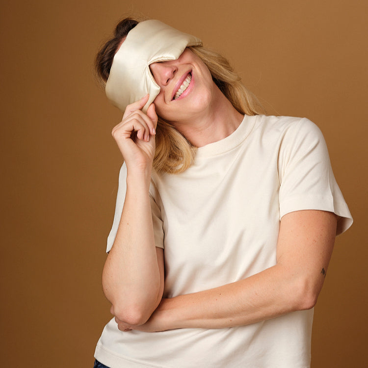 Woman wearing the Emily's Pillow pure silk headband sleep mask in champagne