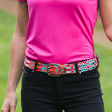 Woman wears ethno-woven-belt-for-women-happy-adriana-smitten with black pants and pink top.