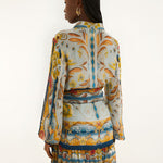 Back view of a model in a studio showcasing the relaxed fit and vibrant mosaic print of the Farm Rio mini dress.